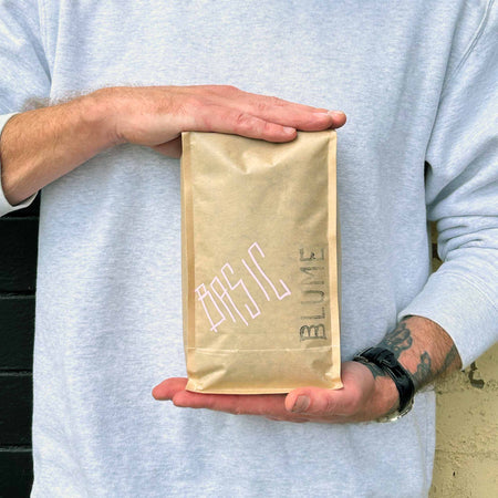 Person holding a bag of basic coffee