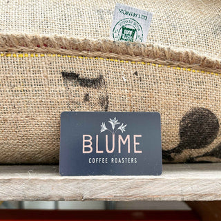 Blume Coffee gift card in front on coffee sack